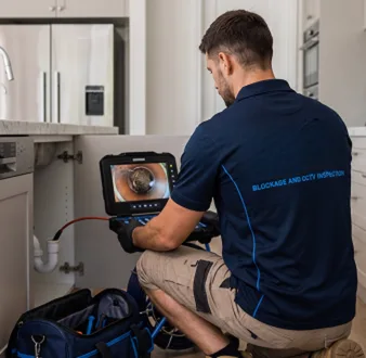 Plumber clearing a blocked toilet in a Rookwood bathroom